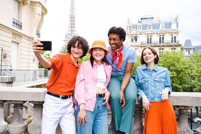 Portrait of smiling friends standing in city