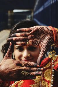 Close-up of young woman with henna tattoo gesturing outdoors