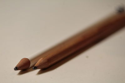 Close-up of colored pencils on table against white background