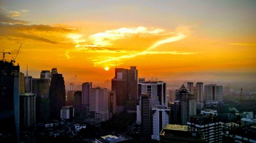 Modern buildings against sky during sunset