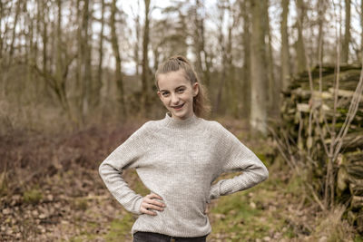 Portrait of smiling teenage girl standing in forest