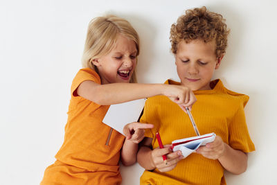 Cute sibling writing in notebook