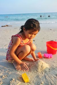 Girl playing with toys at beach