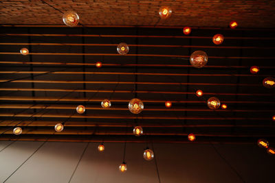 Low angle view of illuminated lights hanging on ceiling