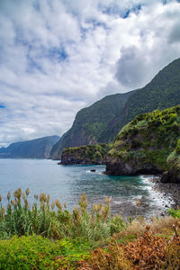 Scenic view of sea and mountains against sky