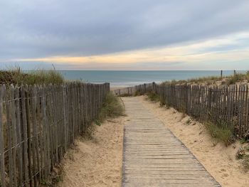 Footpath by sea against sky