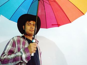 Portrait of boy holding umbrella standing on rainy day
