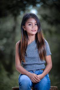 Portrait of young woman looking away while standing outdoors