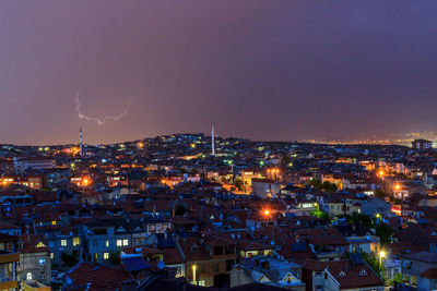 High angle view of illuminated city against sky at dusk