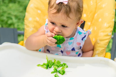 Cute baby eating broccoli