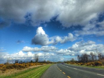 Country road against cloudy sky