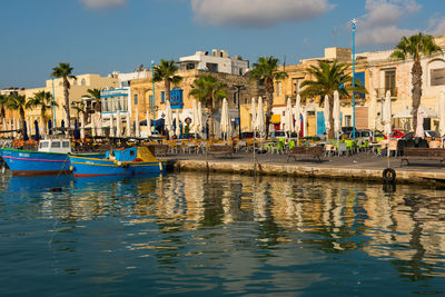 Traditional colorful luzzu fishing boats anchoring in marsaxlokk village harbor