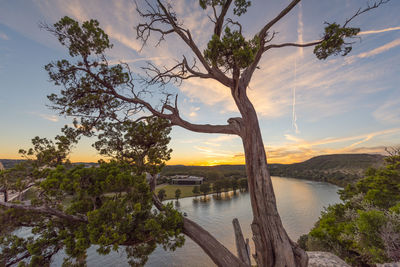 Scenic view of river against sky at sunset