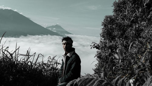 Man standing by plants against sky