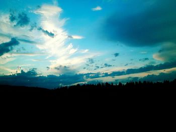 Silhouette of landscape against cloudy sky