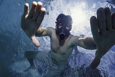 Man underwater with a gas mask.