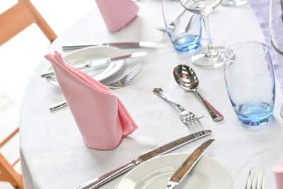 Close up of dinner place setting at formal dinner with pink napkin