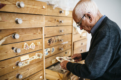 Senior man looking for decals for ceramics