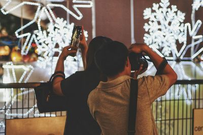 Friends photographing lighting decorations