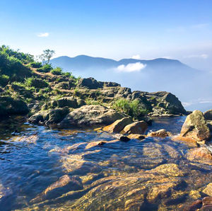 Scenic view of rocks in sea against sky