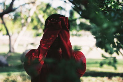 Close-up of woman standing by tree against plants