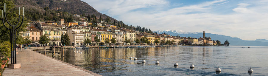 Extra wide view the beautiful lakeside of salò with the lake garda and the monte baldo in background