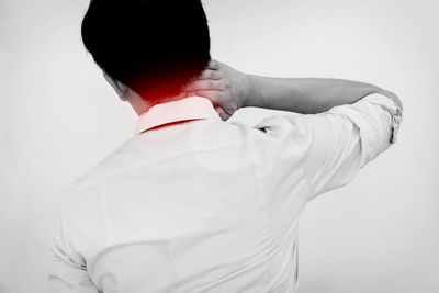 Rear view of man standing against white background