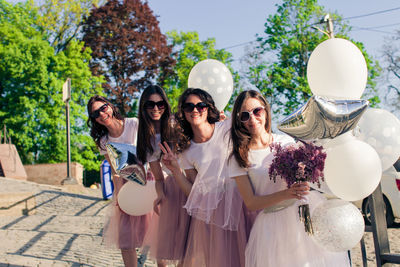 Portrait of smiling young women against plants