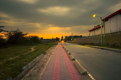 Empty road against sky during sunset