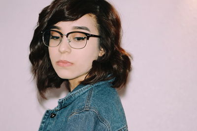 Close-up of upset woman against pink wall