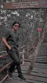 Young man standing against tree