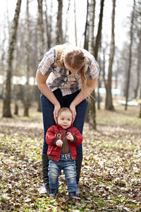 Full length of mother with son on field