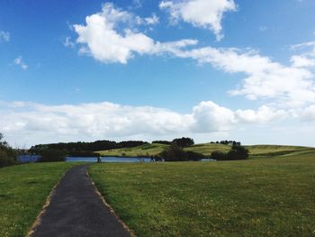 Scenic view of grassy field against cloudy sky