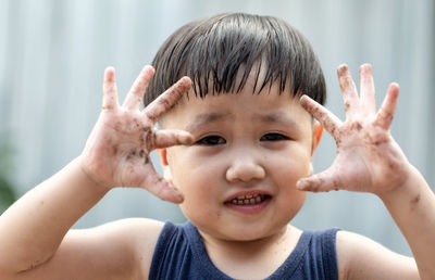 Portrait of cute boy gesturing outdoors