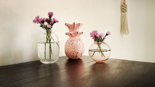 Close-up of flower vase on table against wall at home