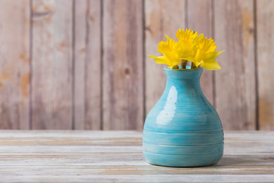 Close-up of yellow flower vase on table