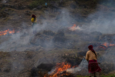 Rear view of women standing by fire