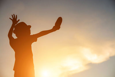 Silhouette woman standing against sky during sunset