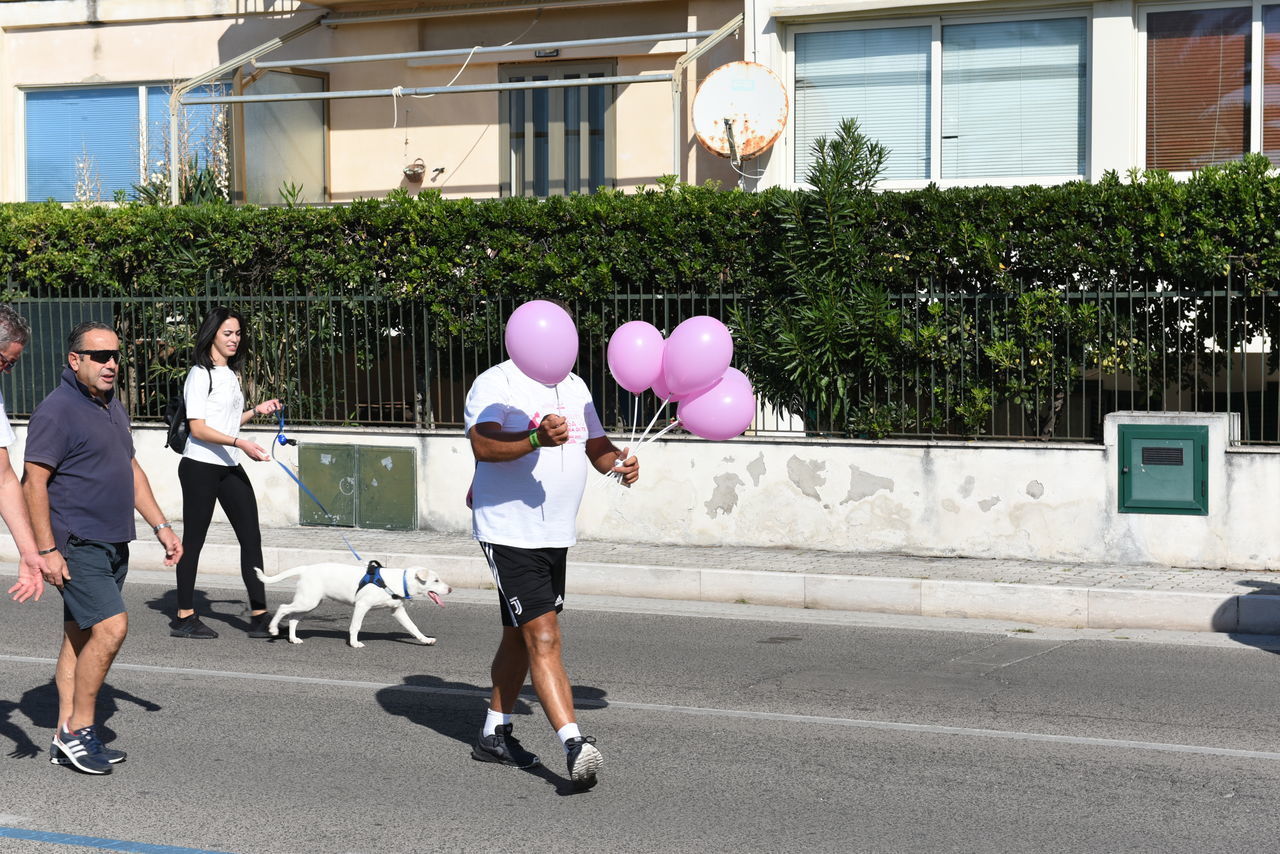 REAR VIEW OF PEOPLE WALKING ON ROAD