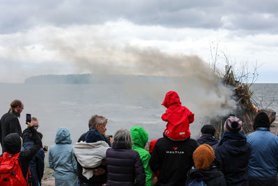 Rear view of people looking at sea against sky