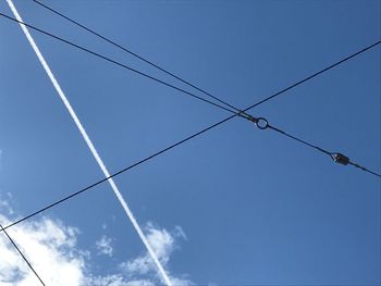 Low angle view of power lines against blue sky