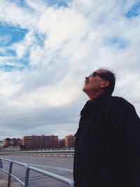 Portrait of young man standing against sky