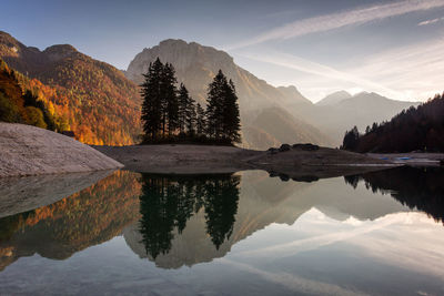 Reflection of trees in lake against sky during sunset