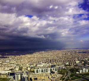 Aerial view of city against cloudy sky