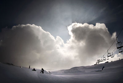 People skiing on snowcapped mountain against sky