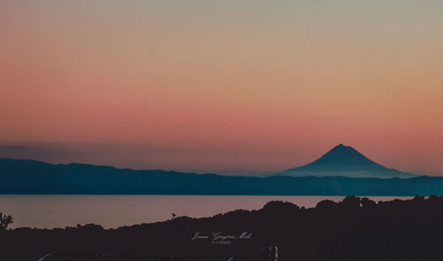 Scenic view of lake against orange sky