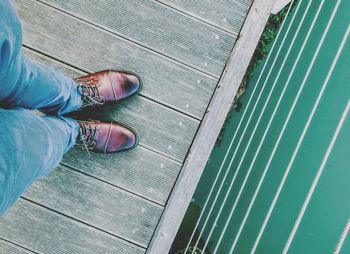 Low section of man standing on pier