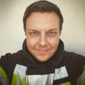 Close-up portrait of smiling young man against wall