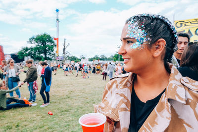 Smiling young woman with drink looking away at party