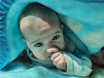 Portrait of cute baby lying on bed